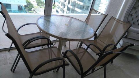 Mesa de comedor exterior y cinco sillas usadas